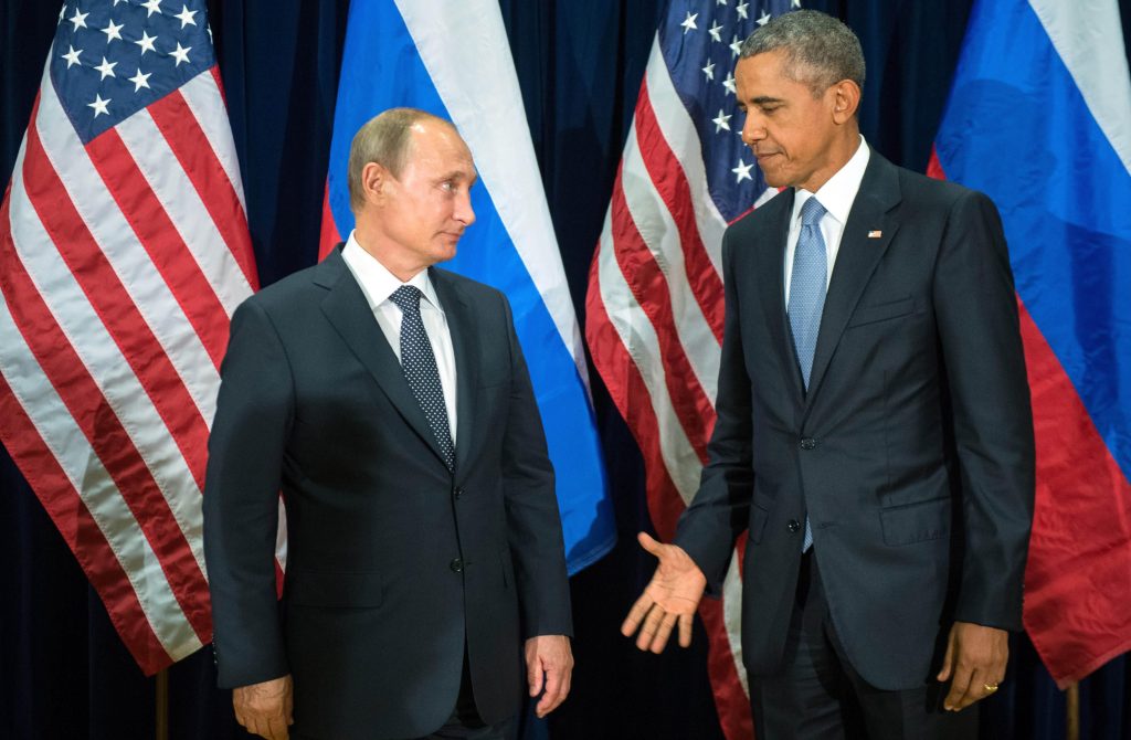 Barack Obama (D) e Vladimir Putin trocam olhares de reprovação antes de cumprimento em encontro na ONU, em 2015 (Sergey Guneyev/RIA-Novosti, Kremlin Pool Photo via AP)
