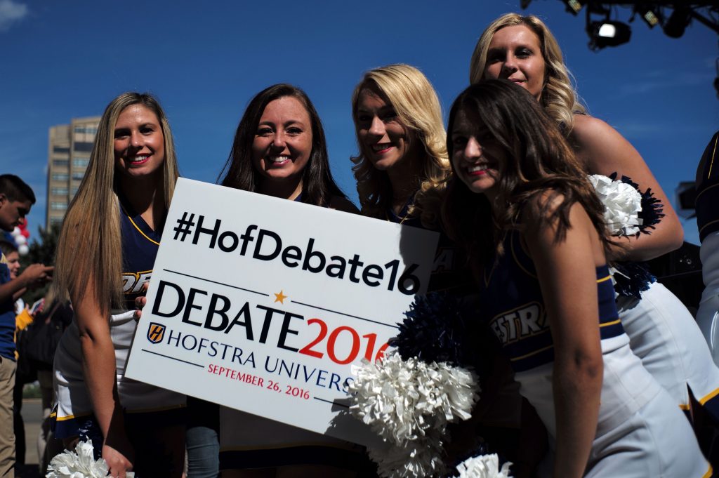 Cheerleaders pose with a sign before US Democratic presidential nominee Hillary Clinton and her Republican counterpart Donald Trump take part in the first presidential debate at the Hofstra University, in Hempstead, New York, on September 26, 2016. Hillary Clinton and Donald Trump prepared to square off Monday in their first presidential debate -- a keenly awaited clash that comes as they sit nearly neck and neck in the polls. / AFP PHOTO / Jewel SAMAD