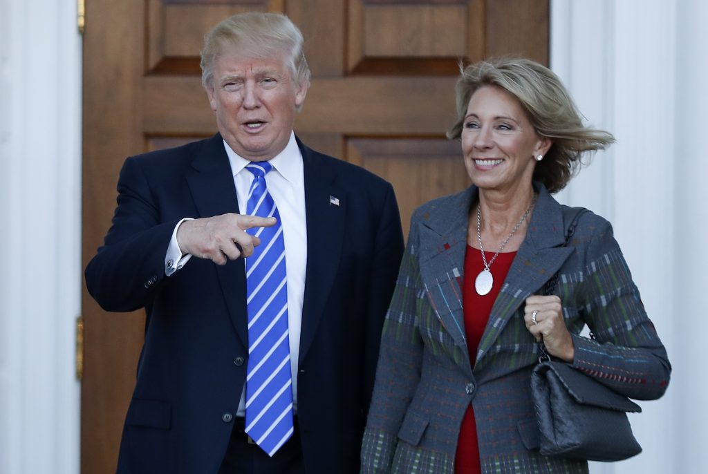 FILE - In this Nov. 19, 2016 file photo, President-elect Donald Trump and Betsy DeVos pose for photographs at Trump National Golf Club Bedminster clubhouse in Bedminster, N.J. Trump has chosen charter school advocate DeVos as Education Secretary in his administration. (AP Photo/Carolyn Kaster, File)