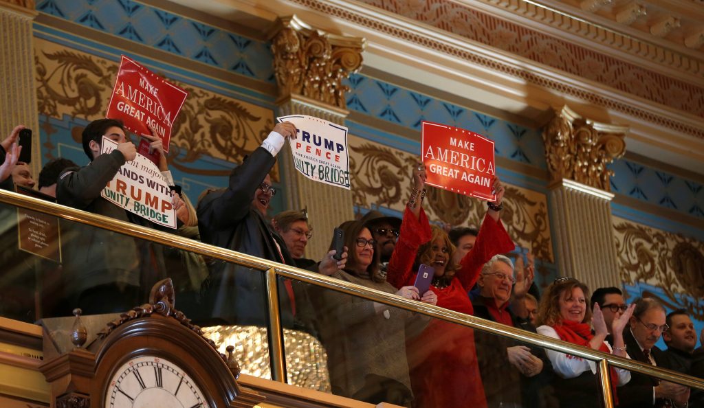 Supporters of President-elect Donald Trump hold signs in the Senate gallery as Michigan's electors cast formal votes for the president and vice president of the United States in Lansing, Michigan, U.S., December 19, 2016. REUTERS/Rebecca Cook