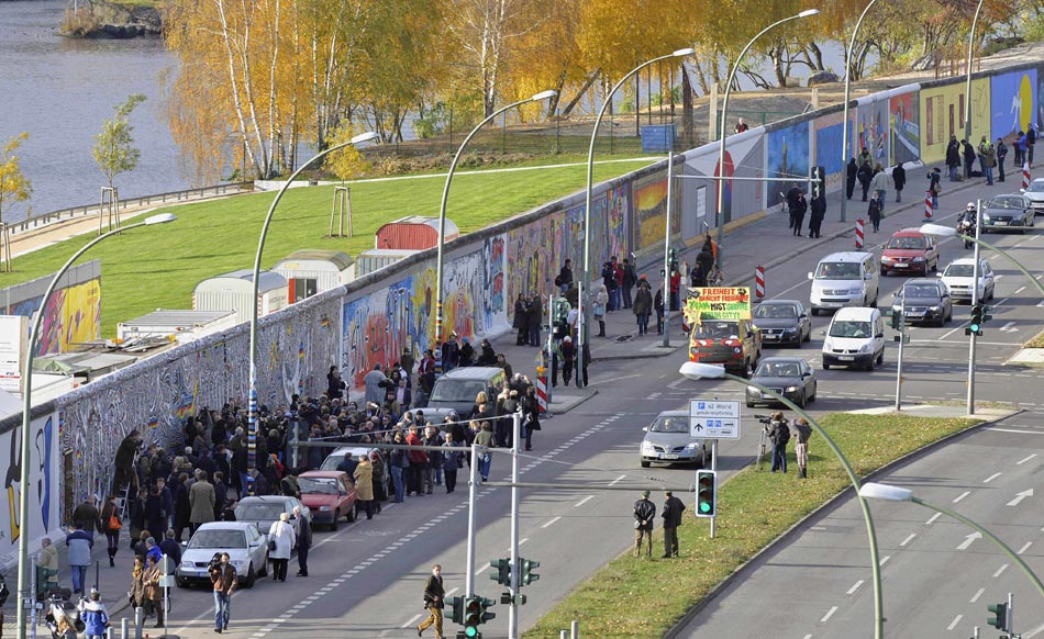 Berlim, 06/11/2009. Turistas observam parte do Muro que virou uma grande "galeria" de arte. Foto: Gero Breloer/AP