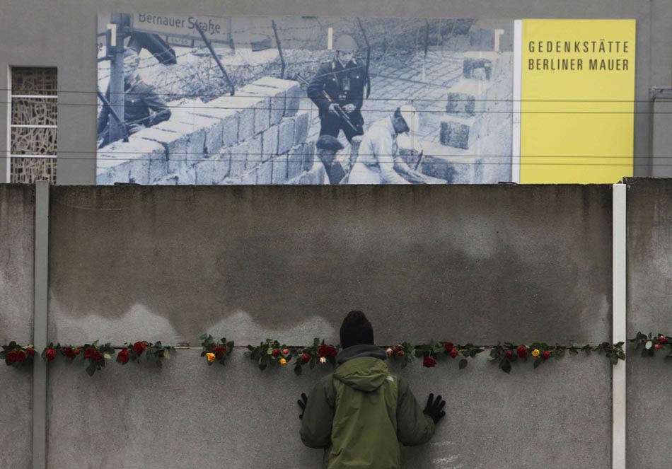 Berlim, 0911/2009. Uma pessoa observa foto no Memorial do Muro. Foto: Pawel Kopczynsk/Reuters