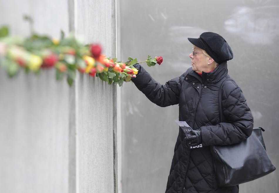 Berlim, 09/11/2009. Uma mulher coloca flores no Memorial do Muro. Foto: Fabian Bimmer/Reuters