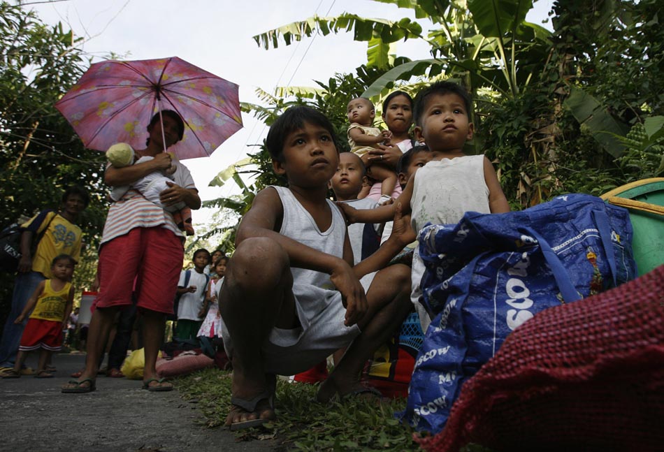 População espera por transporte para deixar a região afetada. Filipinas, 16/12/2009. Foto: Erik de Castro/Reuters