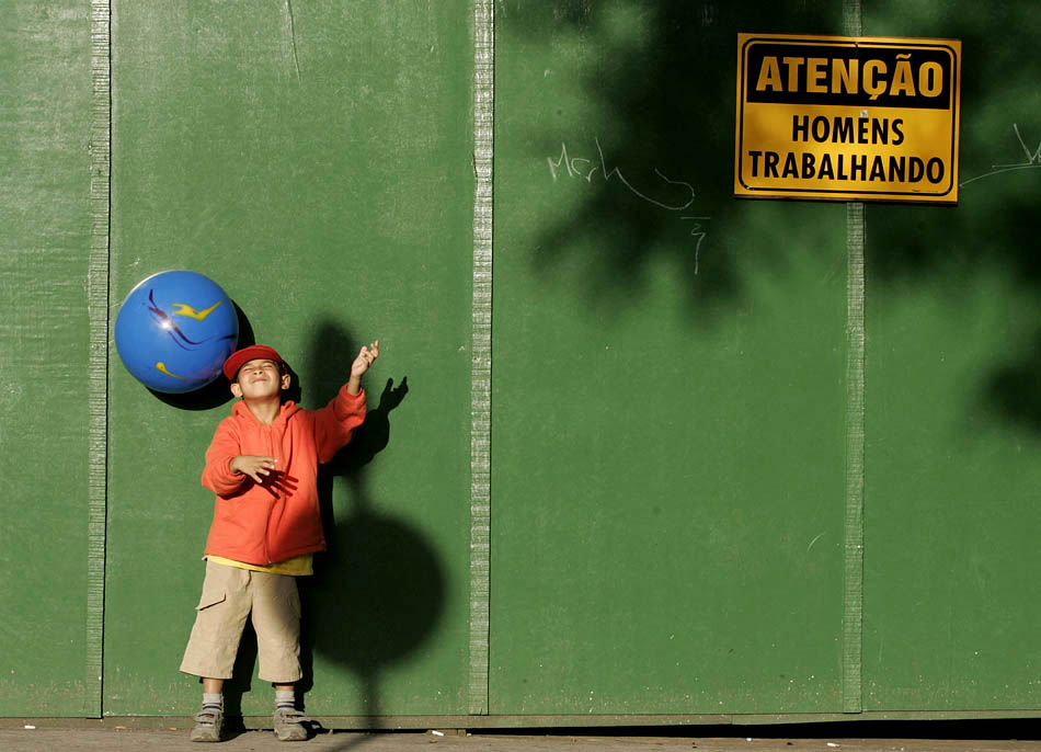 Um menino brinca com a bola em frente a tapume de obra, próximo ao hospital das Clínicas. 19/06/2008. Foto: NILTON FUKUDA/AE