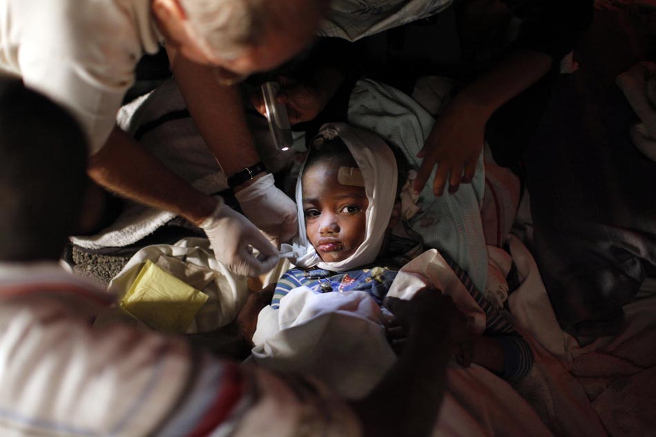 Uma criança ferida recebe os primeiros socorros. Porto Príncipe, 13/01/2010. Foto: Eduardo Munoz/Reuters