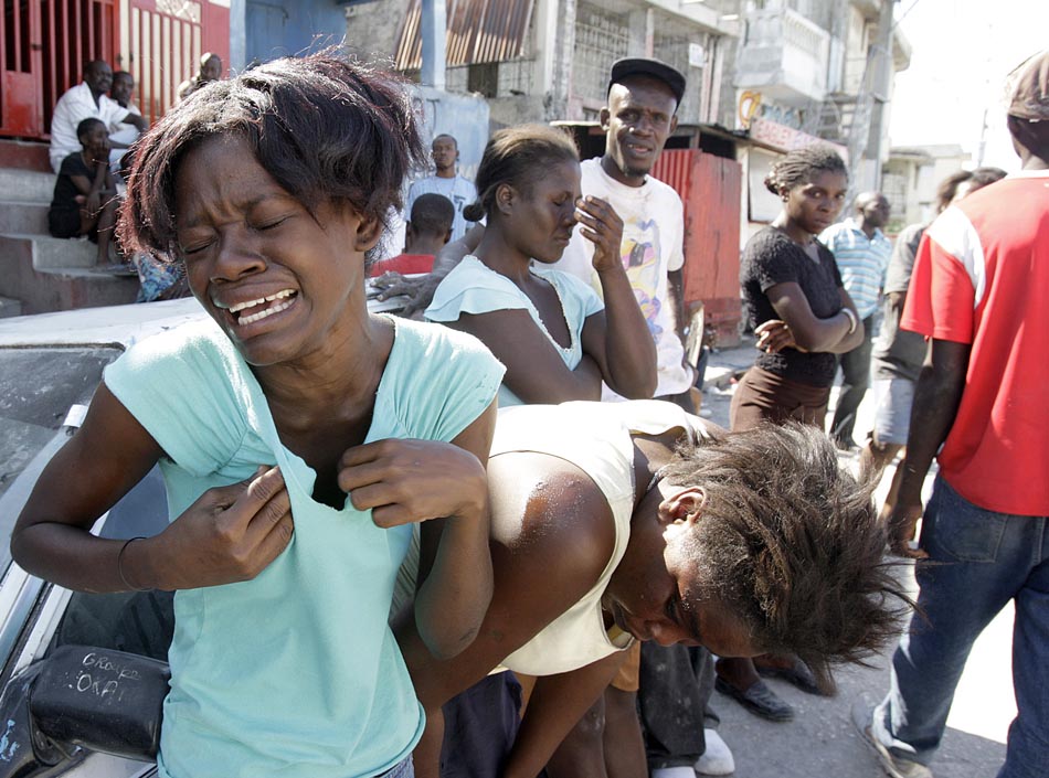 Meninas choram após equipes de resgate localizarem mais vítimas do terremoto. Porto Príncipe, Haiti. 13/01/2010. Patrick Farrell/ The Miami Herald/AP