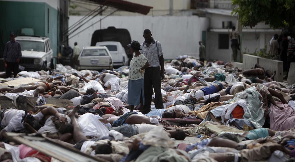 Casal procura por vítimas entre corpos depositados em plena rua. Porto Príncipe, Haiti. 14/01/2010. Foto: Gregory Bull /AP