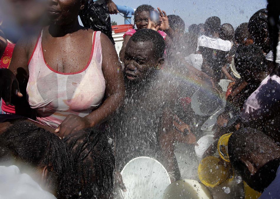 População rompe tubulação em busca de água, em Porto Príncipe. 18/01/2010. Foto: Gregory Bull/AP