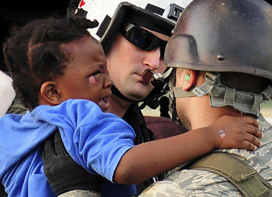 Soldado norte-americano carrega uma criança, vítima do terremoto. Porto Príncipe, Haiti. 12/01/2010. Foto: Candice Villarreal/U.S. Navy/AP