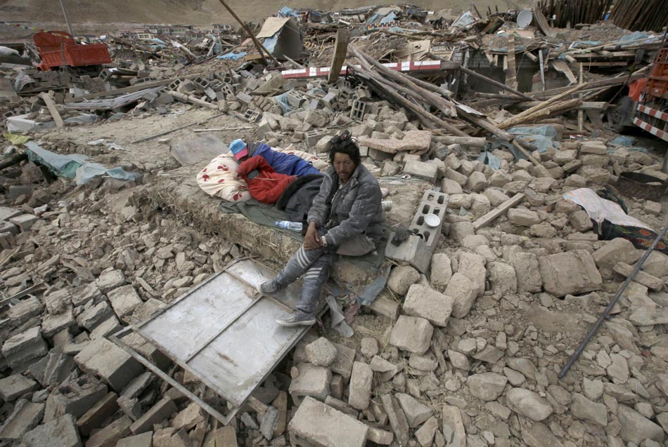 Sobreviventes descansam junto aos destroços. Qinghai, China, 15/04/2010. Foto: Alfred Jin/Reuters