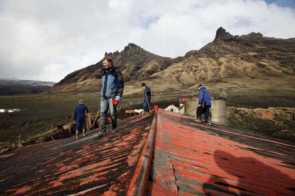 Moradores da região limpam o telhado. Vulcão Eyjafjallajokull, Islândia, 17/04/2010. Foto: Lucas Jackson/Reuters