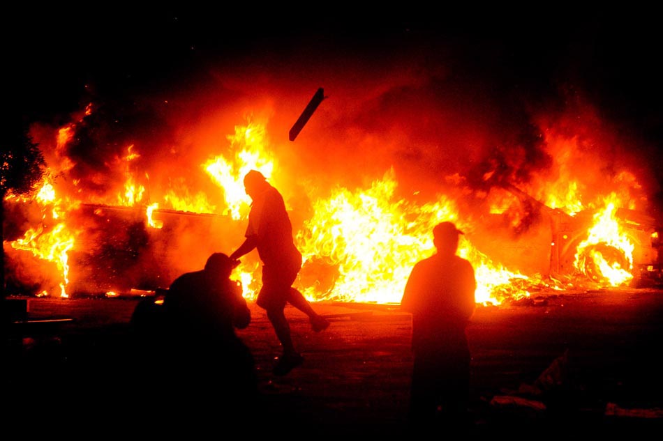 Fogo cruzado: Moradores da favela de Heliópolis ateiam fogo em carro durante protesto contra a morte de uma adolescente, após perseguição de GCMs a bandidos. São Paulo, 01/09/2009. Foto: Sergio Barzaghi/Divulgação