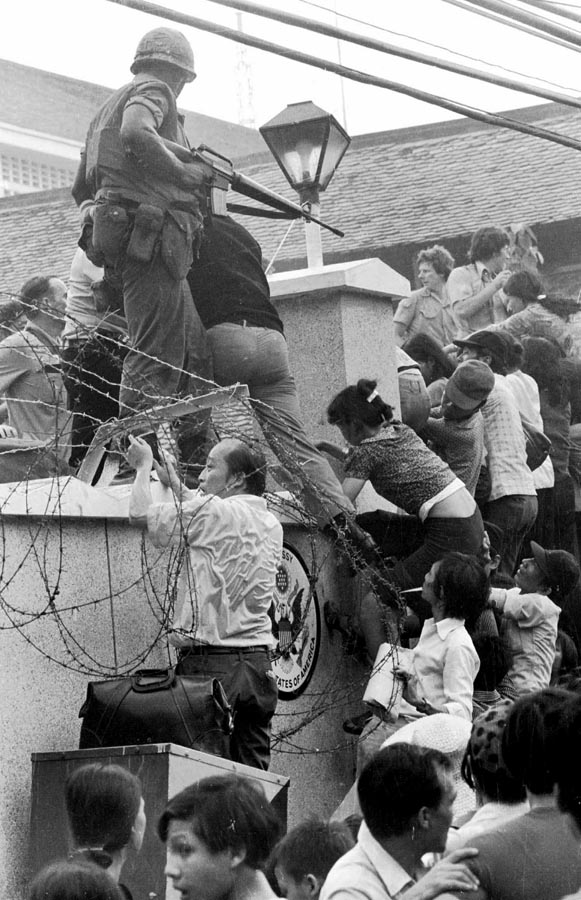 População escala muro da embaixada norte-americana em Saigon, hoje chamada de Ho Chi Minh. 29/04/1975. Foto: Neal Ulevich/AP