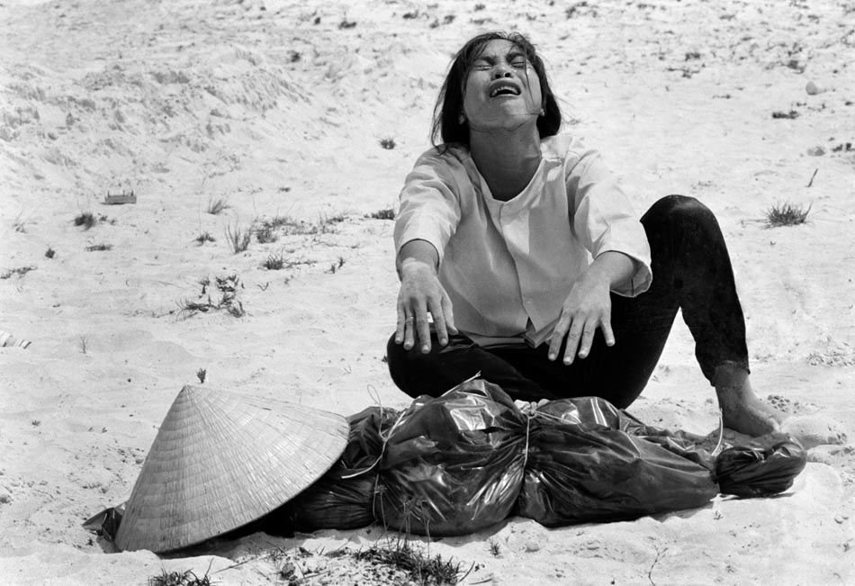Uma mulher sul-vietnamita chora sobre o corpo do marido, encontrado com mais 47 outros em uma vala comum perto de Hue, no Vietnã. 04/1969. Foto: Horst Faas/AP