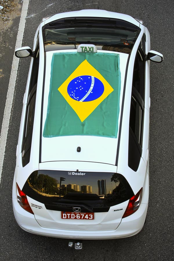 Táxi enfeitado com a bandeira do Brasil no Viaduto Antártica, em São Paulo, antes do jogo de estreia do Brasil na Copa do Mundo. Foto: Andre Lessa/AE