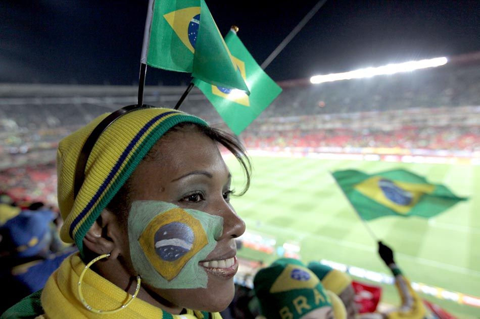 Com uma bandeira do Brasil pintado no rosto, torcedora acompanha o jogo de estreia do Brasil. Estádio Ellis Park, Johanesburgo. 15/06/2010. Foto: Wilton Junior/AE