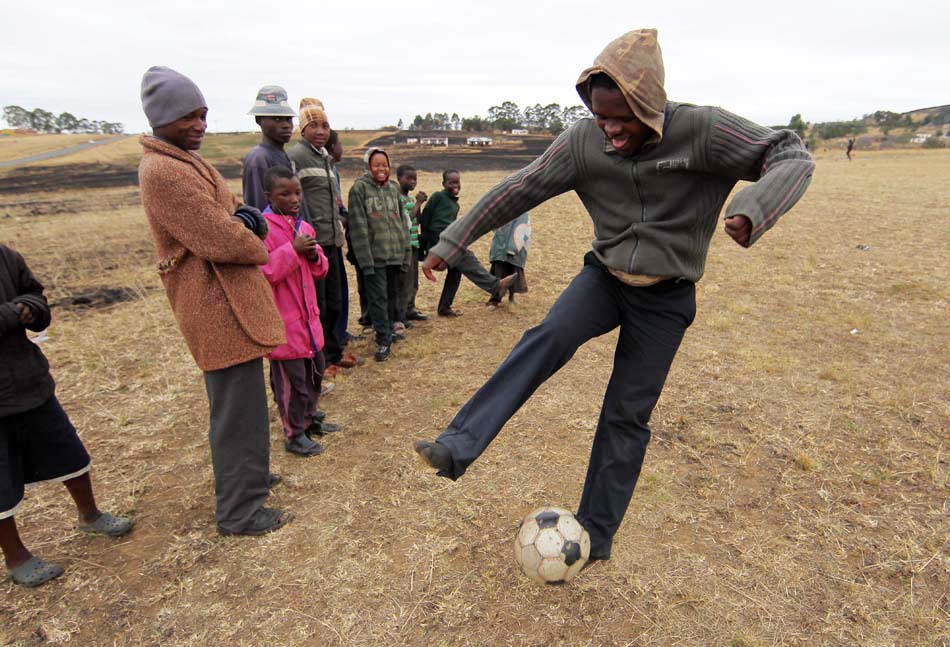 Em outro campo, na estrada que dá aceso a Nkandla, garotos jogam partida de futebol. 10/6/2010. Foto: Evelson de Freitas/AE