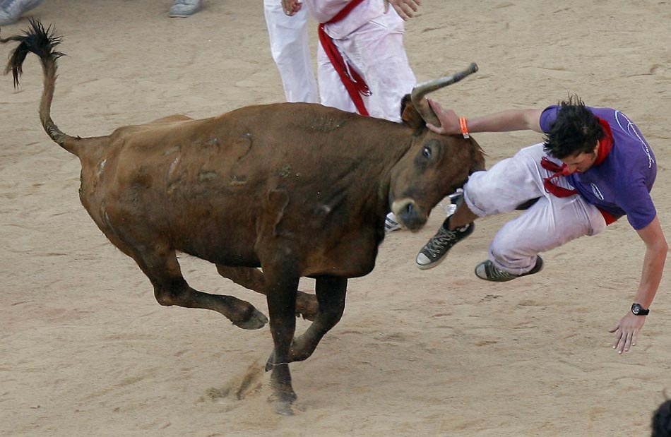 Participante da festa é atingido durante a corrida com touros. Mesmo causando acidentes, tradição é mantida. Pamplona, Espanha. 07/07/2010. Foto: Joseba Etxaburu/Reuters