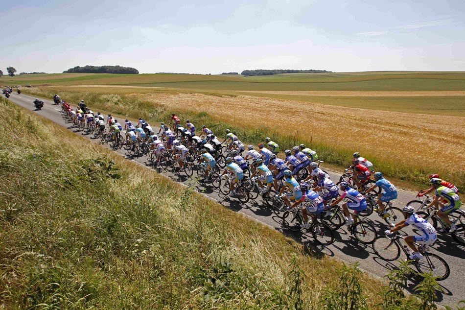 Ciclistas passam por campo ao norte da França, na 4ª etapa do Tour de France. 07/07/2010. Foto:Bas Czerwinski/AP