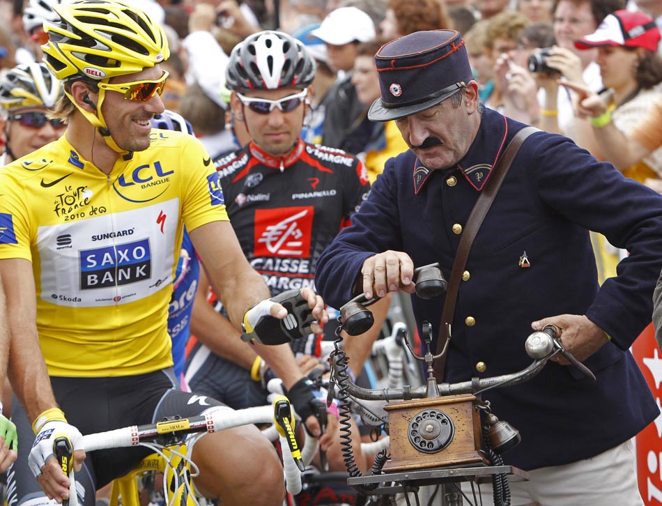 Suíço, Fabian Cancellara, conversa com francês vestido com roupas antigas de carteiro. 09/07/2010. Foto:Christophe Ena/AP