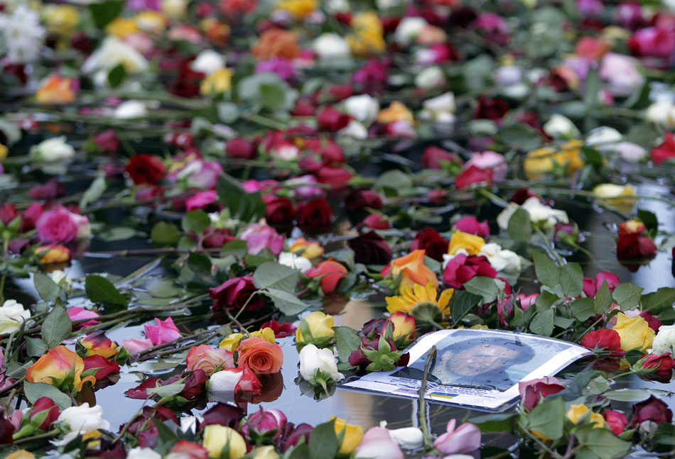 Em meio às flores, a foto de uma das 3 mil vítimas. 11/09/2010. Foto:John Angelillo/AP