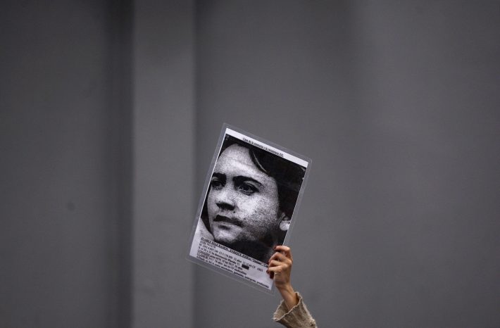 A member of the audience holds up a picture of Enrique Juarez Diaz Ramos, who disappeared during Argentina's 1976-83 military dictatorship, at the trial of former Argentine de facto president and army chief Reynaldo Bignone and other officers in Buenos Aires April 20, 2010. Bignone, 81, the last military president in Argentina's 1976-1983 dictatorship, will be sentenced today on charges of kidnapping, torture and murder of 56 people in a concentration camp. The former general who ruled Argentina in 1982-1983, and seven other former military and police officers faced a three-judge panel on charges including the ordering of beatings, waterboardings and electrocutions at the Campo de Mayo army base. REUTERS/Marcos Brindicci (ARGENTINA - Tags: POLITICS CRIME LAW)