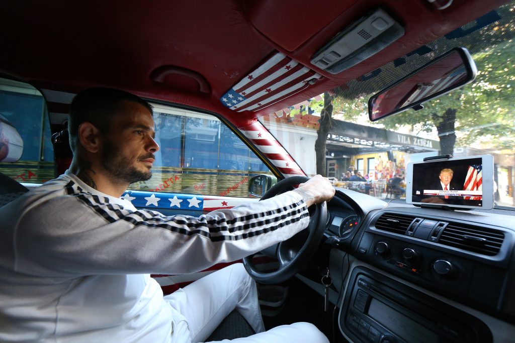 Uljan Kolgjegja afirma que está ganhando mais dinheiro do que jamais ganhou durante os 13 anos em que trabalha como motorista de táxi (Foto: AP Photo/Hektor Pustina)