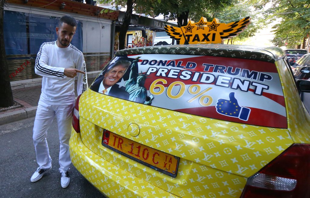 Uljan Kolgjegja, de 37 anos, ao lado do seu táxi decorado em homenagem a Donald Trump (AP Photo/Hektor Pustina)